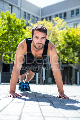 Handsome athlete doing push-ups on the floor