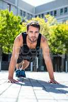 Handsome athlete doing push-ups on the floor