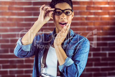 Gorgeous hipster with arm crossed posing with glasses