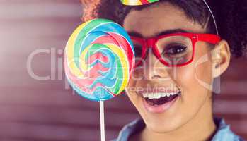 Young woman holding a lollipop against her face