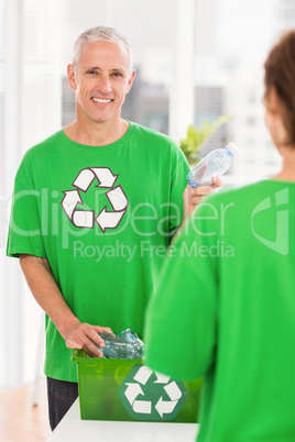 Smiling eco-minded man holding recycling bottle