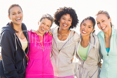 Laughing sporty women with arms around each other