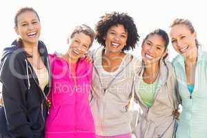 Laughing sporty women with arms around each other