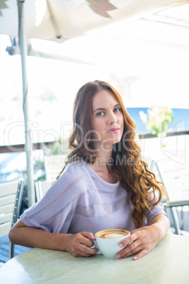 Pretty brunette enjoying a cappuccino