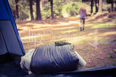 Sleeping bag in front of blonde camper walking away
