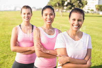 Three smiling women wearing pink for breast cancer