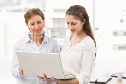 Smiling businesswomen using laptop