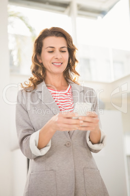 Smiling casual businesswoman using smartphone