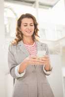 Smiling casual businesswoman using smartphone