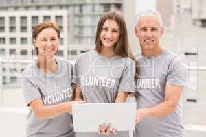 Smiling volunteers with laptop