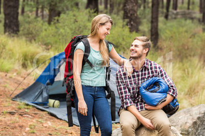 Young pretty hiker couple holding a sleeping bag and backpack