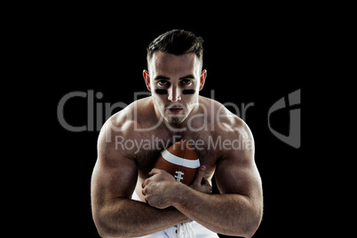 Shirtless American football player with ball