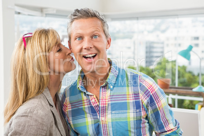 Casual designer giving her colleague kiss on cheek