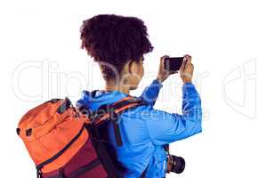 Young woman with backpack taking picture