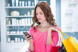 Pretty woman sending a text while shopping