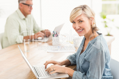 Smiling business team working on laptops