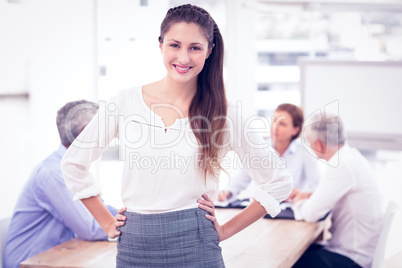 Smiling pretty businesswoman in front of colleagues