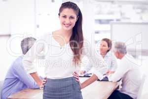 Smiling pretty businesswoman in front of colleagues