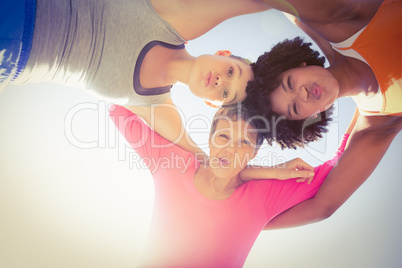 Sporty women with arms around posing down to camera