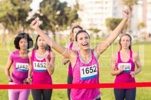 Cheering brunette winning breast cancer marathon