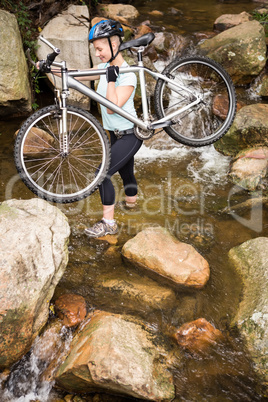 Profile view of a fit woman lifting her bike