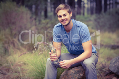 Portrait of a handsome man sitting on a stone