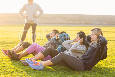 Sporty women doing sit ups during fitness class