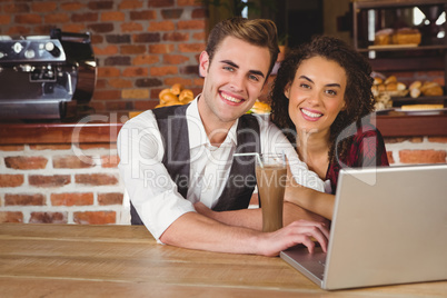 Cute couple on a date watching photos on a laptop