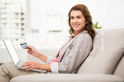 Casual businesswoman sitting on couch and ordering online
