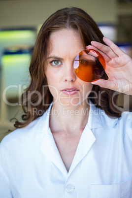 Serious optician holding up lens