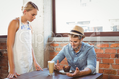 Handsome hipster complaining to blonde waitress