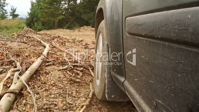 Offroader Overcomes Obstacle on a Dirt Road in the Forest
