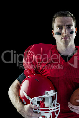 American football player holding helmet