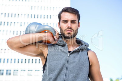 Handsome athlete holding kettle bell