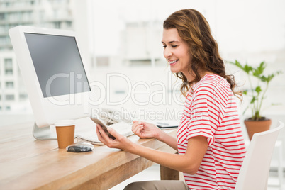 Smiling casual businesswoman using smartphone