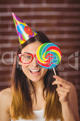 Pretty hipster with party hat and lollipop