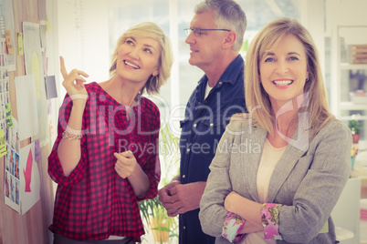 Businesswoman with arms crossed with her team behind
