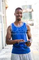Smiling athletic man using tablet computer