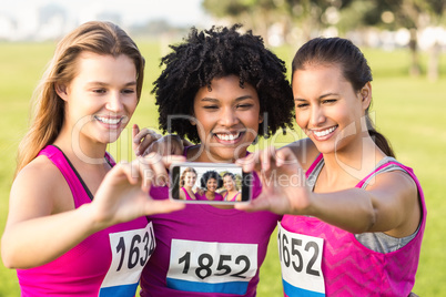 Runners supporting breast cancer marathon and taking selfies