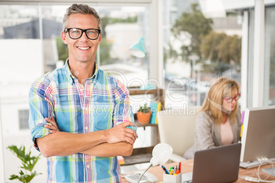 Smiling casual designer in front of his working colleague