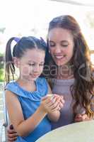 Mother and daughter enjoying cakes at cafe terrace