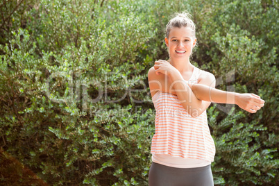 Smiling blonde athlete stretching arms