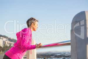 Sporty woman stretching on railing