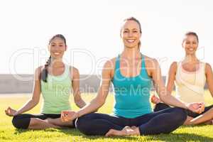 Smiling sporty women doing yoga together