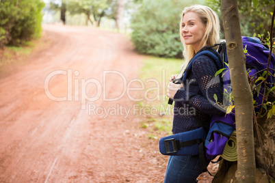 Smiling female hiker waiting by the side of the road