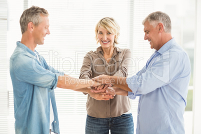 Smiling business colleagues stacking hands