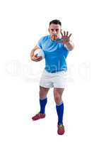 Rugby player looking at camera with hand up