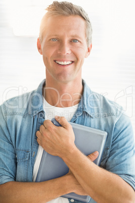 Smiling businessman holding a tablet