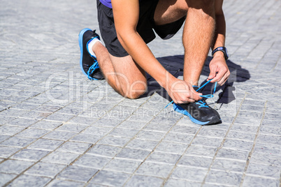 Athlete tying his shoes on a sunny day