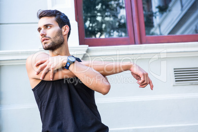 Handsome athlete stretching his arm